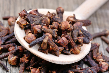 Cloves in a wooden spoon on table