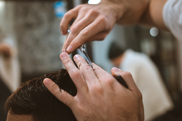 Obraz na płótnie Canvas Closeup of smiling man getting an haircut from barber