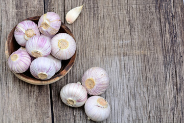 Fresh garlic in a wooden bowl on table