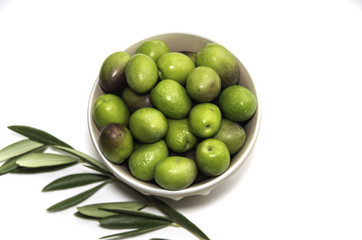 Plate of Green olives ready to eat in white background.