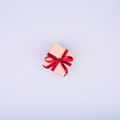 Craft box with red ribbon bow. Valentine day concept. Trendy minimalistic flat lay design background