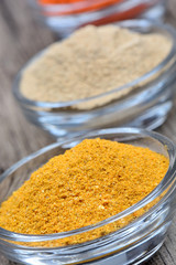 Bowls with spices on wooden table