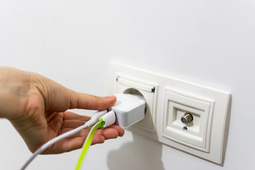 Girl putting phone charger into the socket