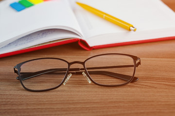 glasses on the desktop with a notebook in the background