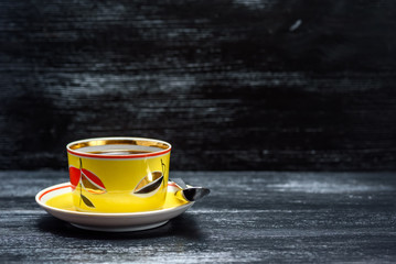 tea in a yellow mug on a black wooden background