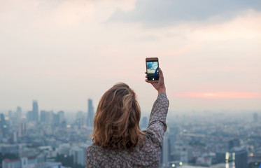 Woman taking a photo of the sunset