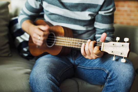Caucasian man practicing ukulele