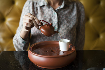 Woman pouring tea into a cup