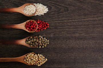Spices in spoons on a wooden surface