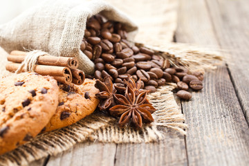 Coffee beans with biscuits and spices on canvas fabric closeup