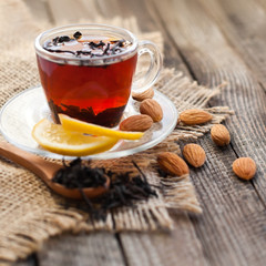 Tea in a cup with lemon and nuts closeup