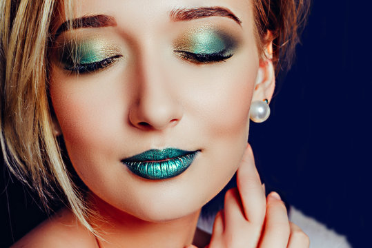 Close-up of a blonde woman with green make-up