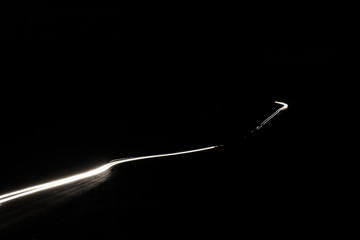 Country road with white light trails in the night .