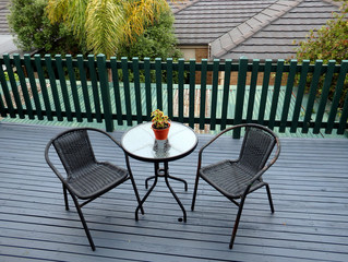 little steel table and chair on a deck