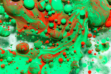 Toxic chemical acrylic oil droplets on water creating the idea of pollution concepts ideas and themes in bright vibrant colours, as the circle globules release on the liquid surface. Abstract globes