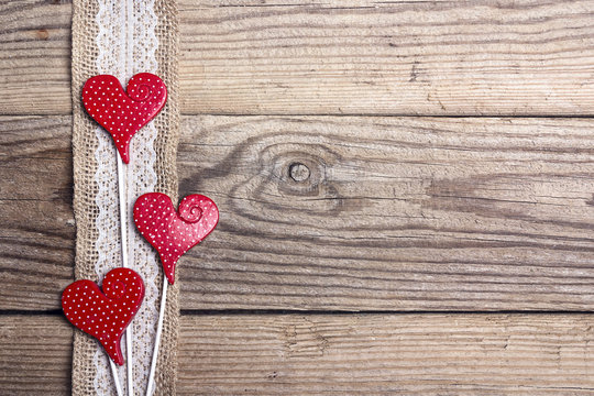 Rustic wooden background with sacking border and hearts. Copy space.