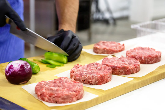 The chef prepares a Burger with beef, salad and vegetables.