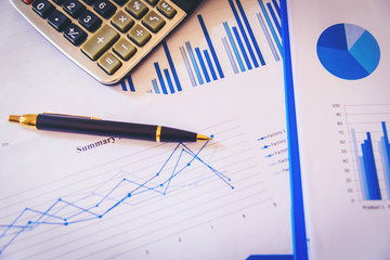 Many charts and graphs with magnifying glass and many pencil. Reflection light and flare. Concept image of data gathering and statistical working.