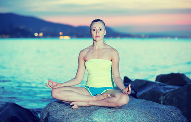 Fototapeta na wymiar Young girl in yoga pose lotos