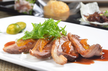 Slices of duck fried meat on a white plate    