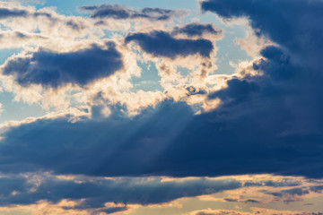 Fototapeta na wymiar rays of the sun make their way through dramatic clouds