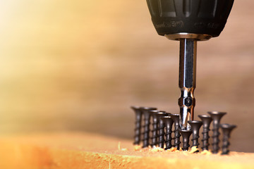 Close up Electric drill on wooden table background and copy space.  Hammer drill or screwdriver, Electric cordless hand drill on wooden. maintenance home concept. Screwdriver on a wooden background wi