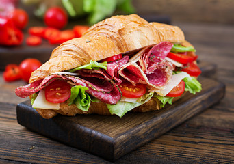 Tasty breakfast. Appetizing croissant with salami and, cheese and tomatoes