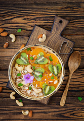 Tasty and healthy oatmeal porridge with fruit, berry and nuts. Healthy breakfast. Fitness food. Proper nutrition. Top view