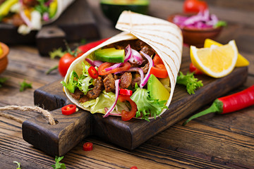 Mexican tacos with beef in tomato sauce and avocado salsa