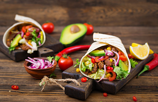 Mexican tacos with beef in tomato sauce and avocado salsa