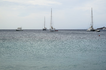 Soft beautiful ocean seascape with sailing boats, yachts and clear sky background, Ornos beach