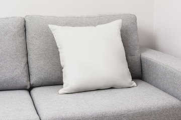 Blank white pillow on a couch.
