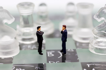 Miniature people, Businessmen stand on opposite sides of the chess game, separate party , benefit, use as a business competition concept.