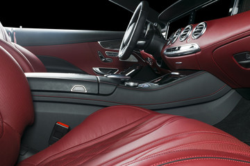 Modern Luxury car inside. Interior of prestige modern car. Comfortable leather seats. Red perforated leather cockpit. Steering wheel and dashboard. automatic gear stick shift. Car interior details