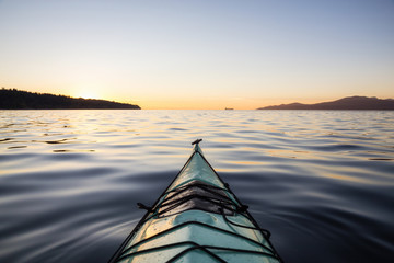 Kayaking during a vibrant Sunset. Taken in Jericho Beach, Vancouver, British Columbia, Canada.