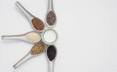 Grain seeds plant in a glass spoon on a white background.