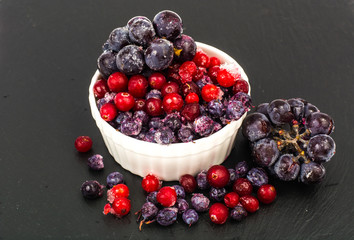 Mix of frozen berries on black background