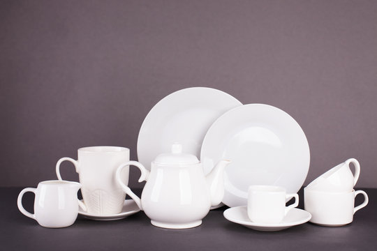 set of white utensils for lunch and tea party on a gray background