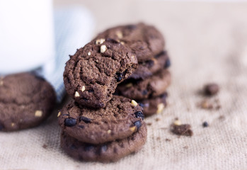 Chocolate chip cookies stacked on sackcloth background.