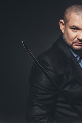 close-up shot of modern samurai with katana sword on black