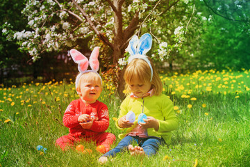 happy kids on easter eggs hunt in spring