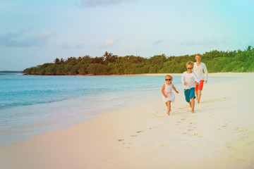 Naklejka premium father with little son and daughter run at beach