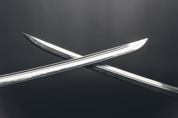 Close-up shot of crossed katana blades on black