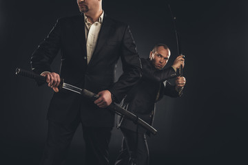 two mature modern samurai with katanas isolated on black