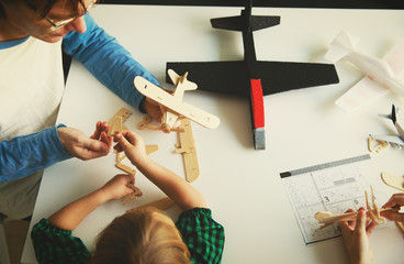 teacher and kids making toy wooden planes