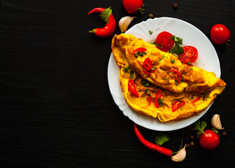 omelette in a plate on dark wooden background with copy space. top view