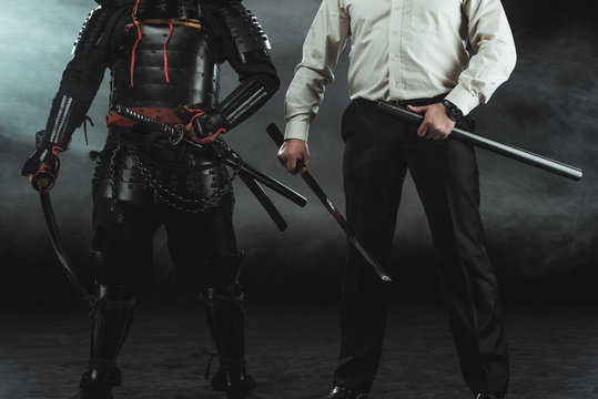 Cropped Shot Of Modern Man And Samurai With Katana Swords On Black