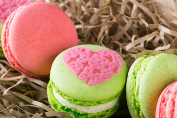 pink heart lies on the green background of the pasta Macaron, to the day of the holy Volentin