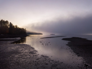 Aerial view of the fog covering North Vancouver, British Columbia, Canada, during a vibrant sunrise