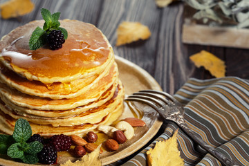 Homemade pancakes with honey and berry fruit. Closeup, selective focus.